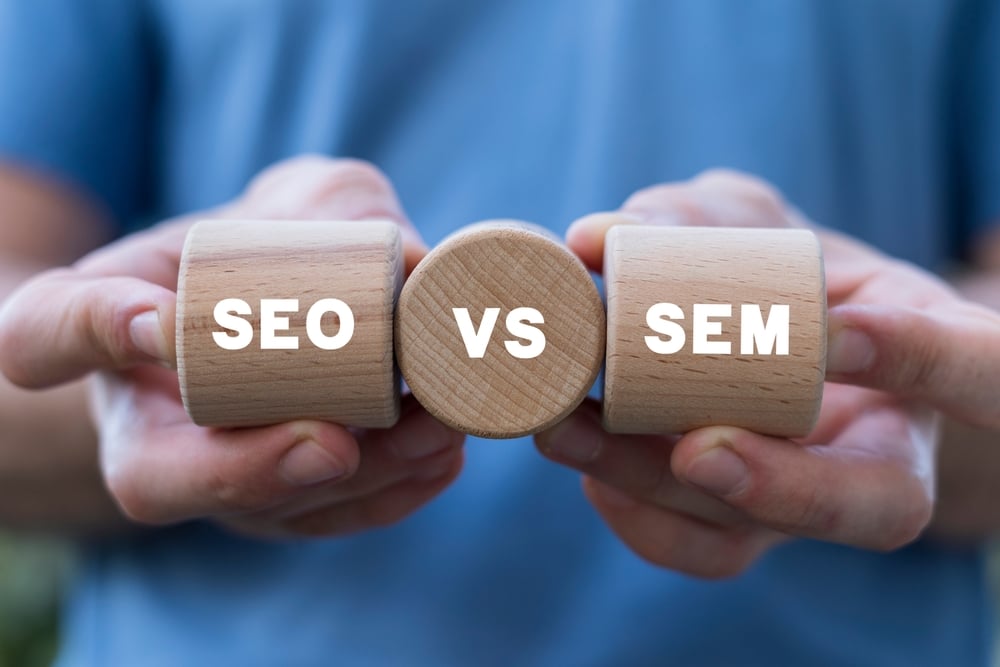 three blocks held together with words SEO vs SEM printed on them. 